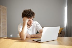 etudiant frustre face a son ordinateur pour un cours en PDF